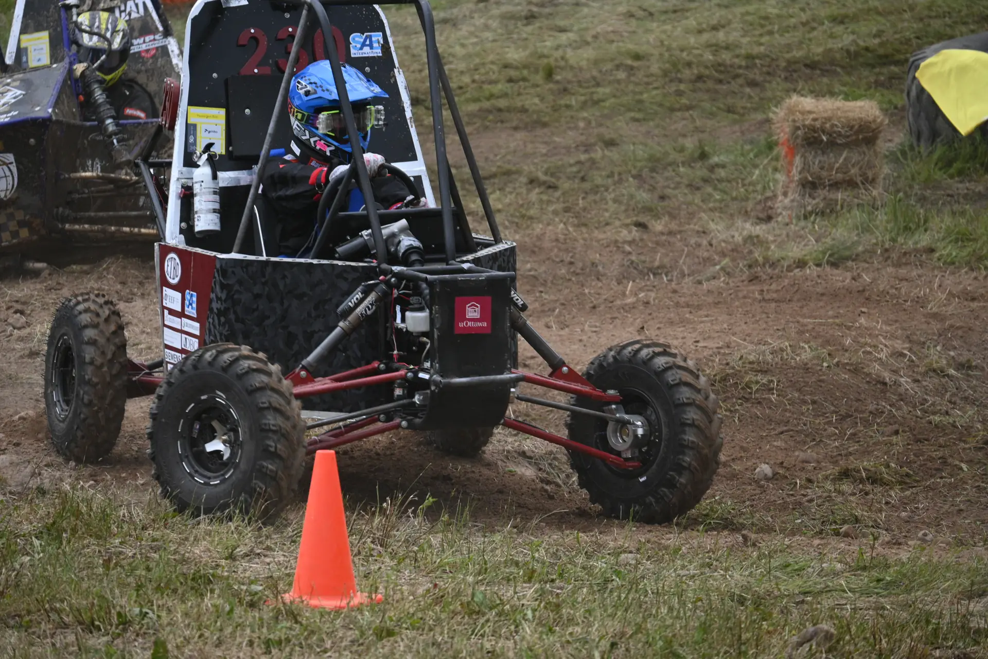 Car #230 turning past a cone