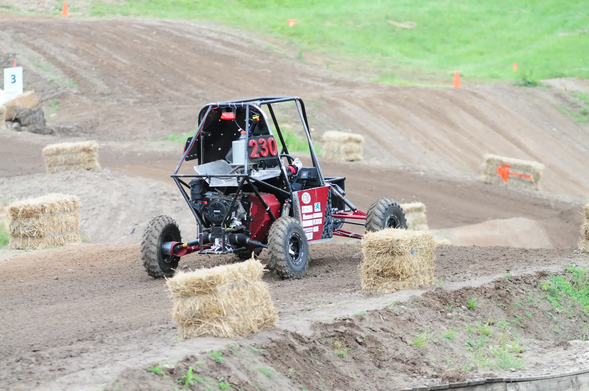Rear view of car #230 on course, showing the engine and drivetrain