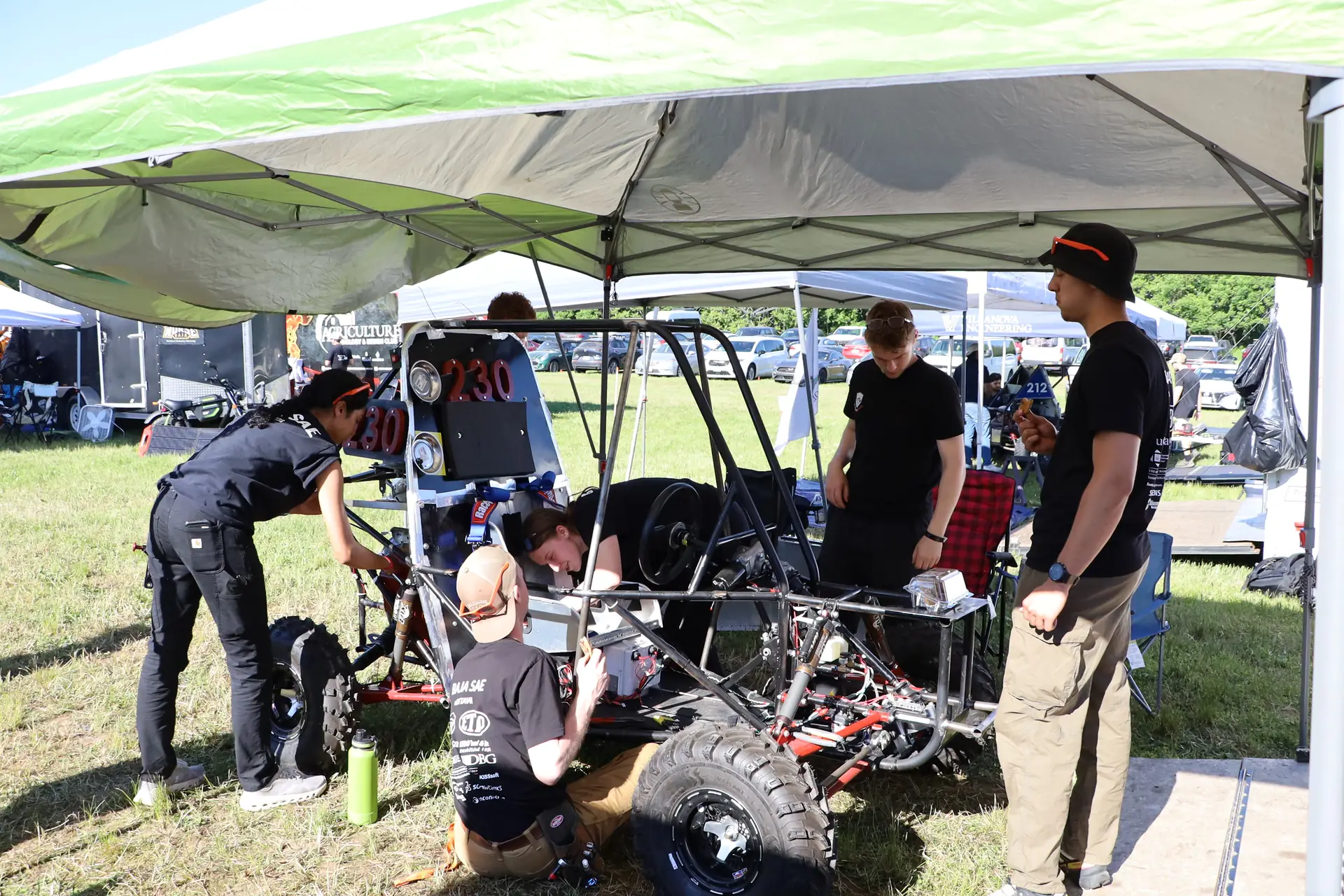 Team working on the car under the tent