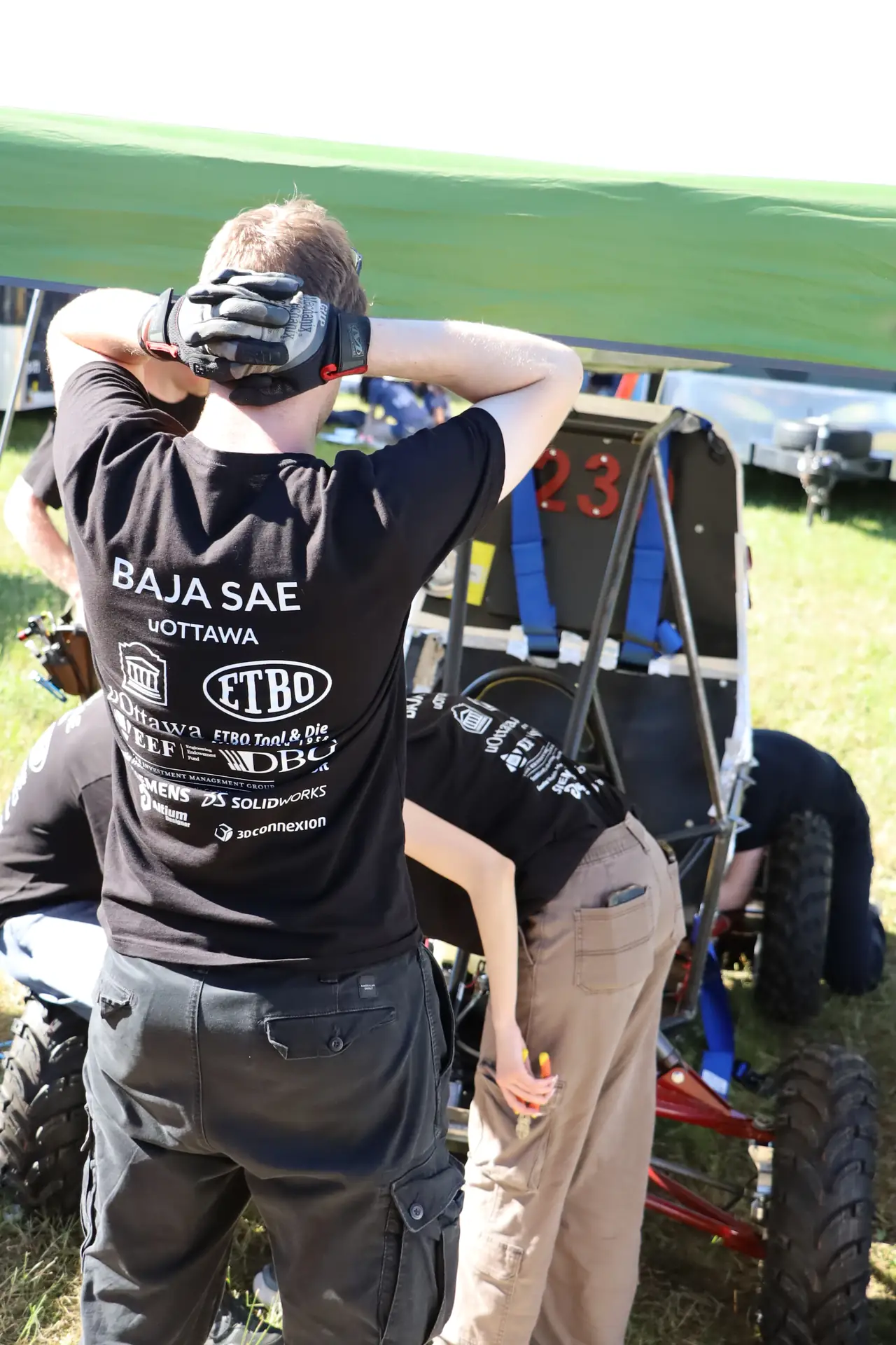 Team member in a Baja SAE uOttawa shirt watching the car