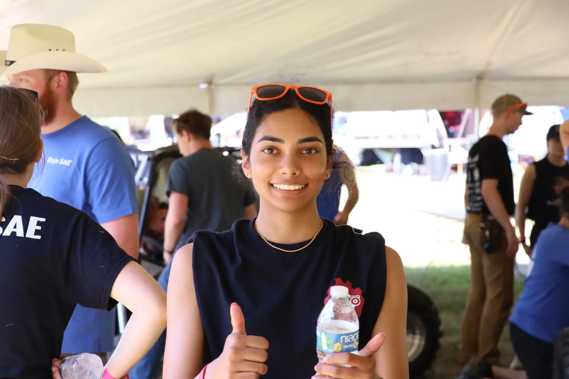 Team member giving a thumbs up under the inspection tent