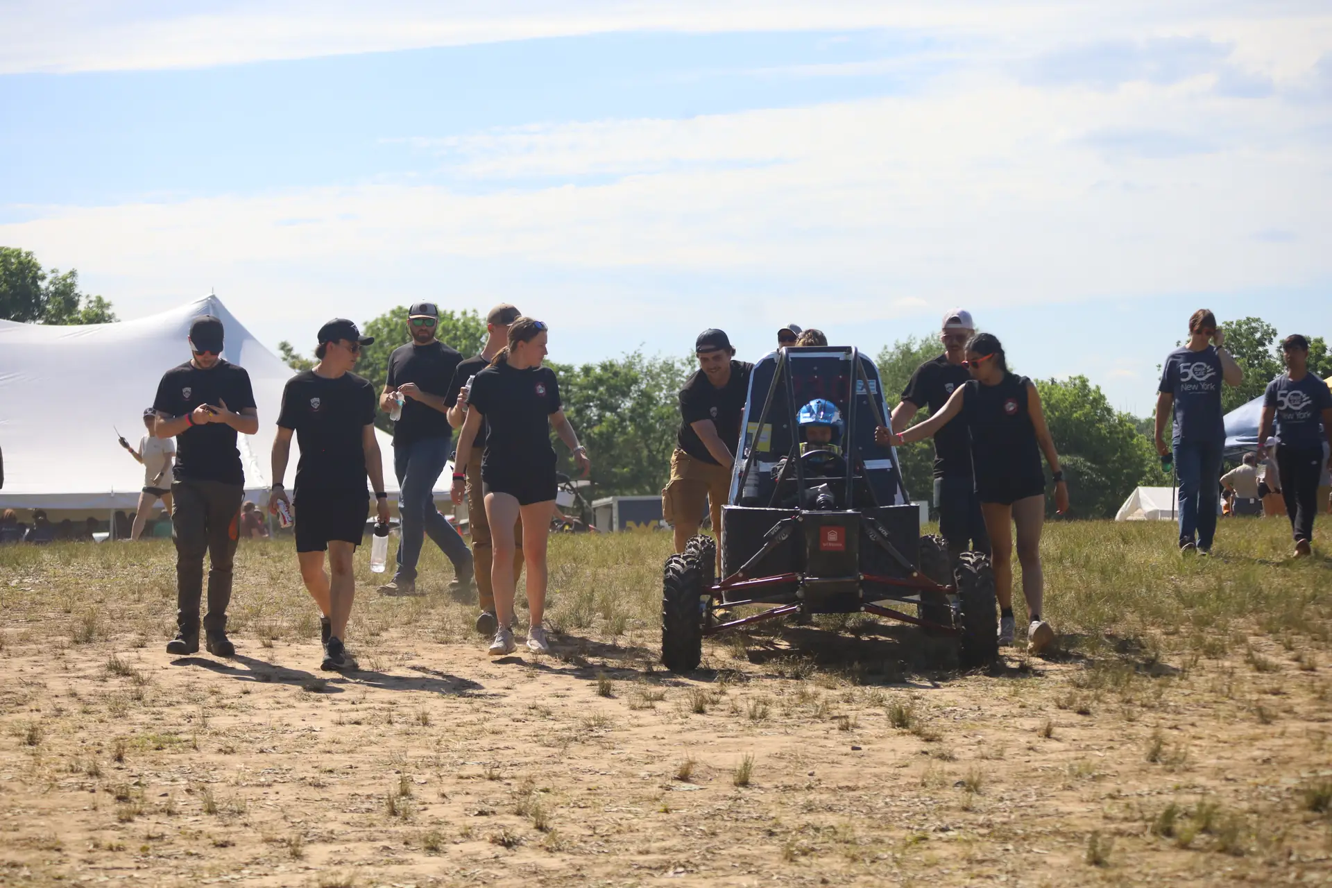 The team walking car #230 across the paddock