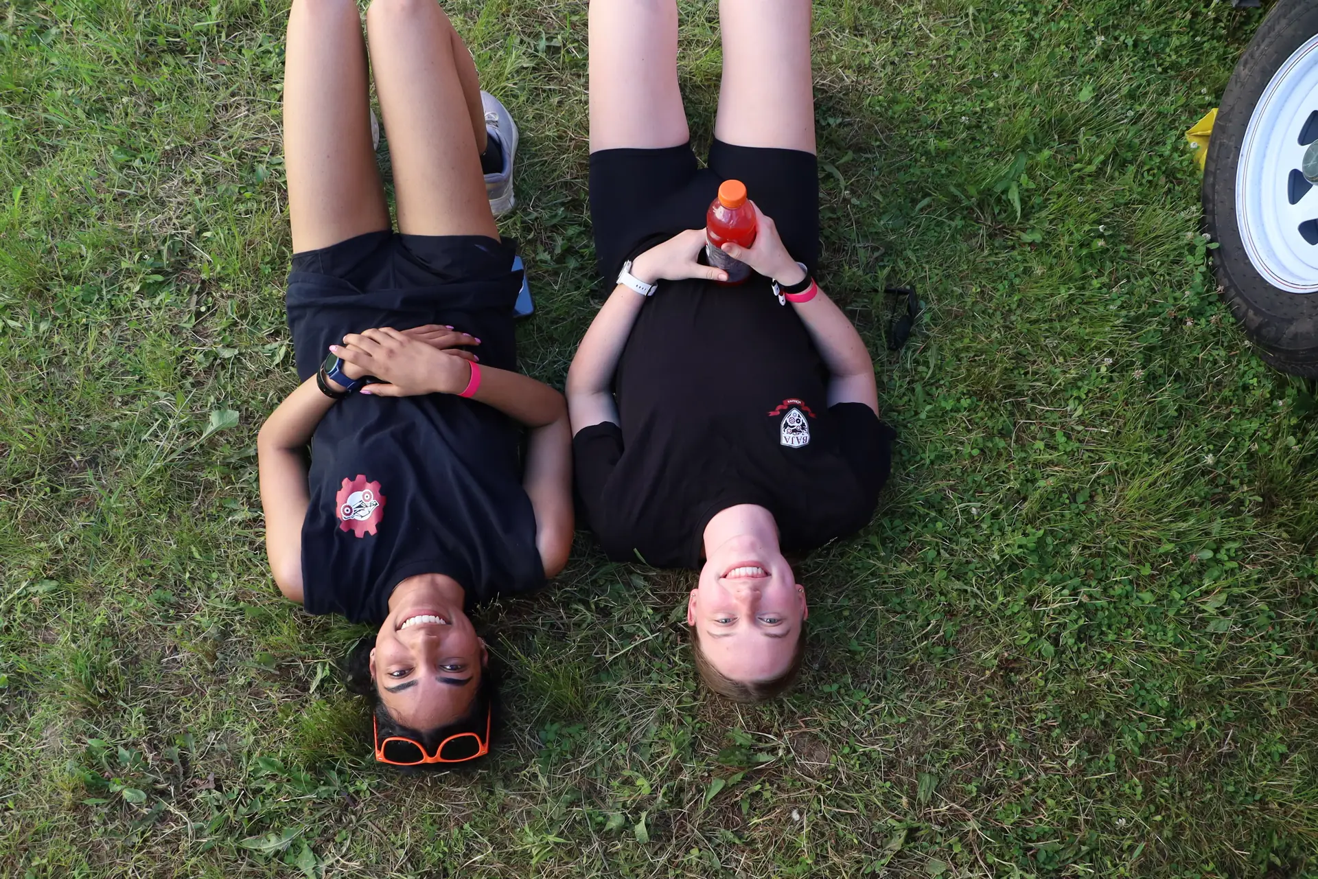 Two team members lying in the grass between events