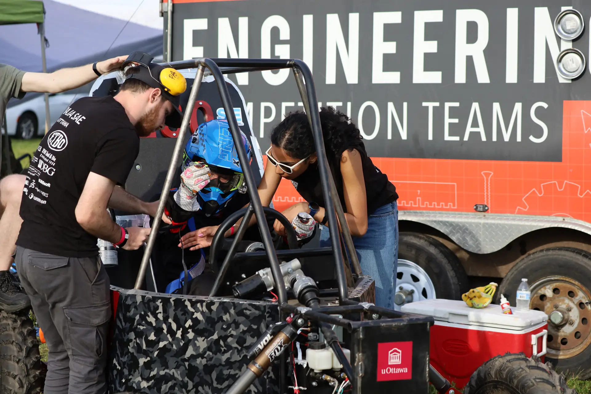 Team working on the car beside the team trailer