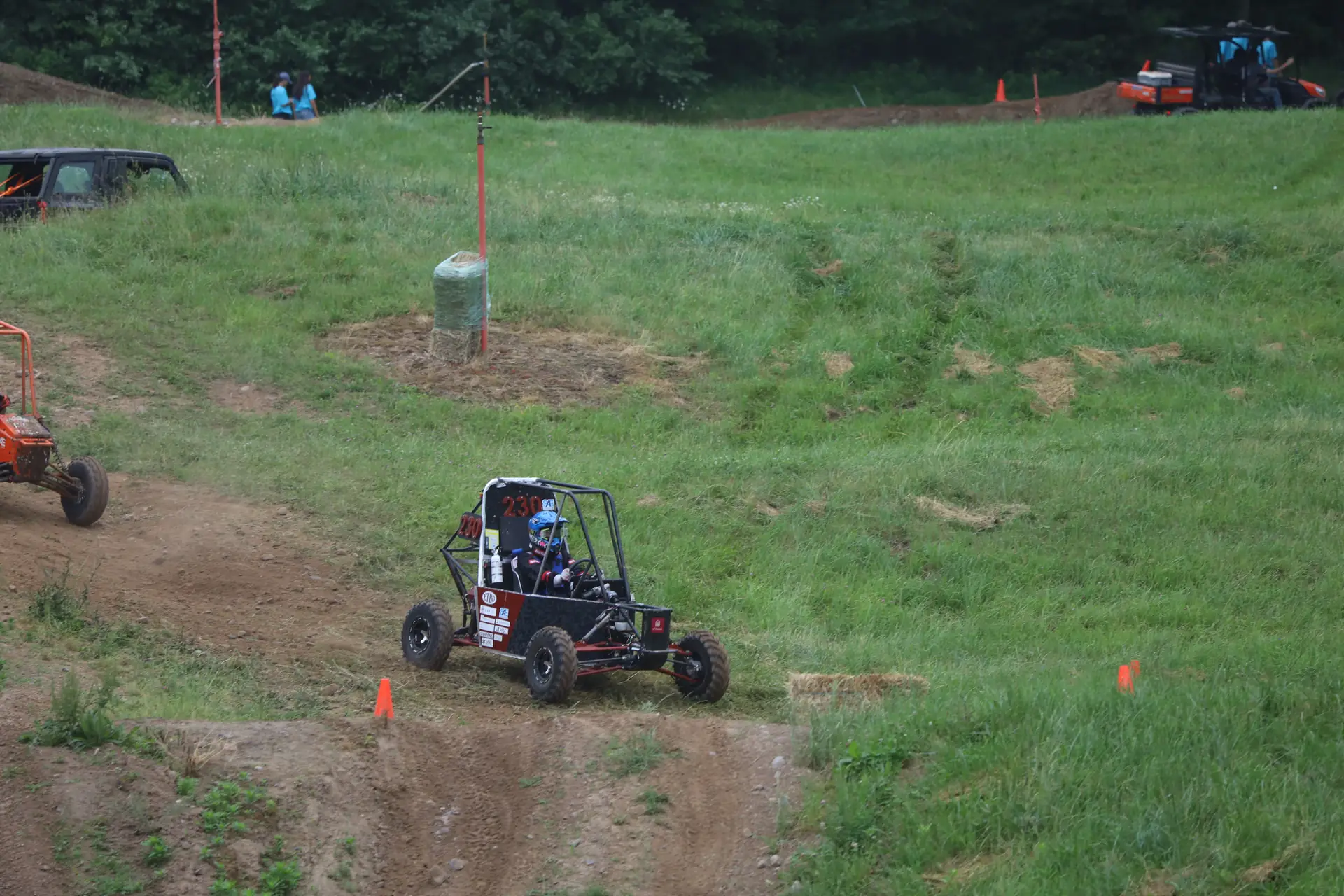 Car #230 driving across a grassy slope