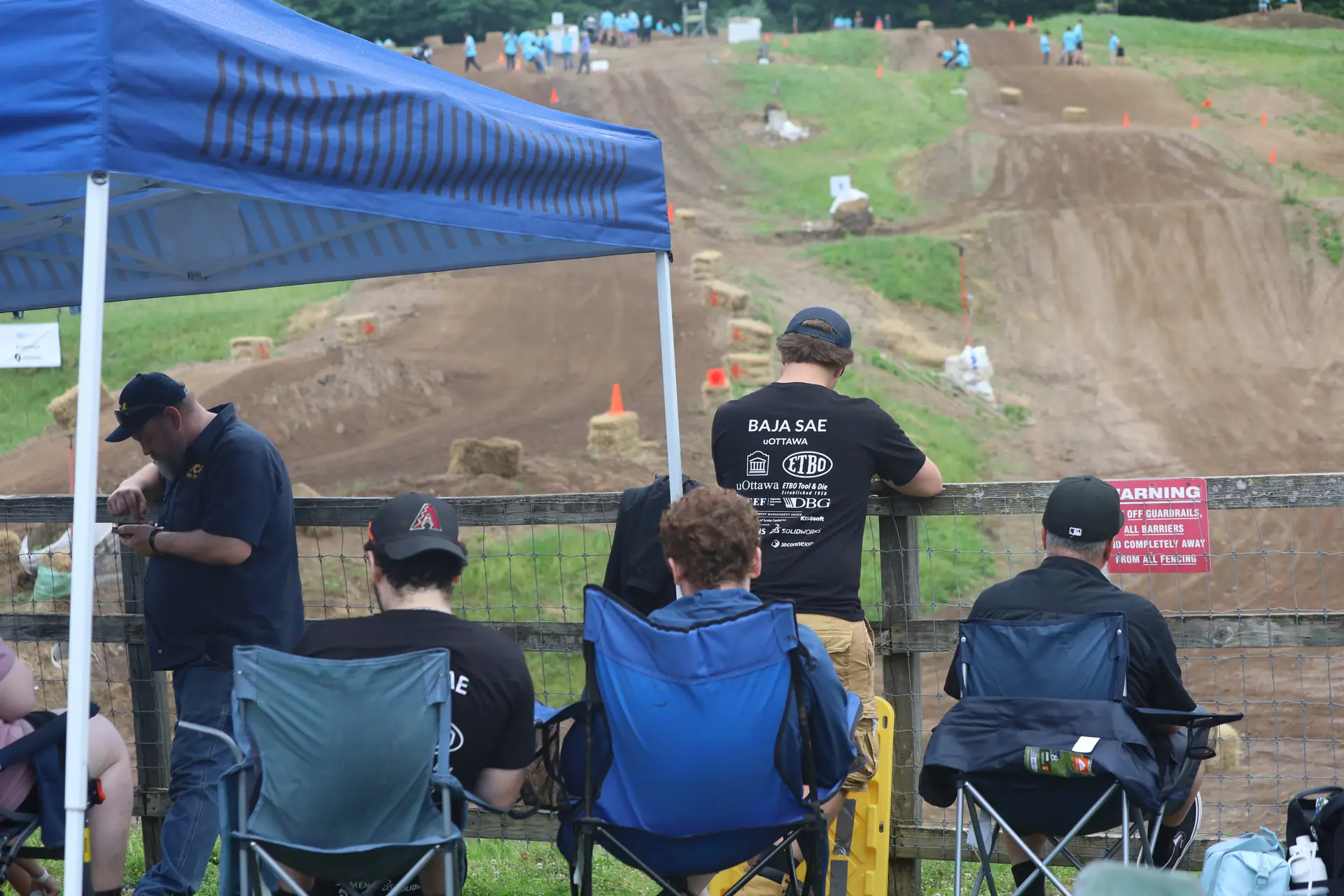 Team members watching from the fence line