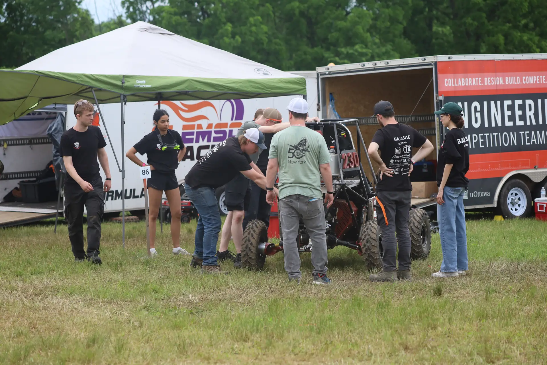 Team gathered around the car in the paddock