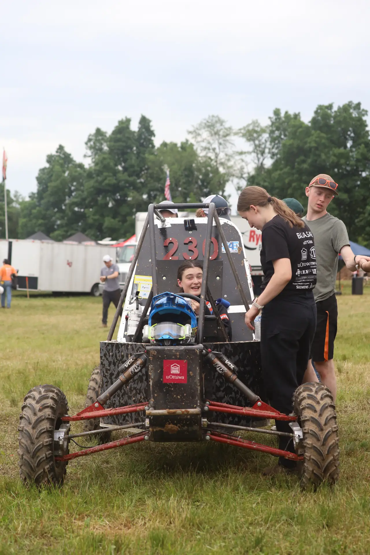 Car #230 surrounded by team members in the paddock
