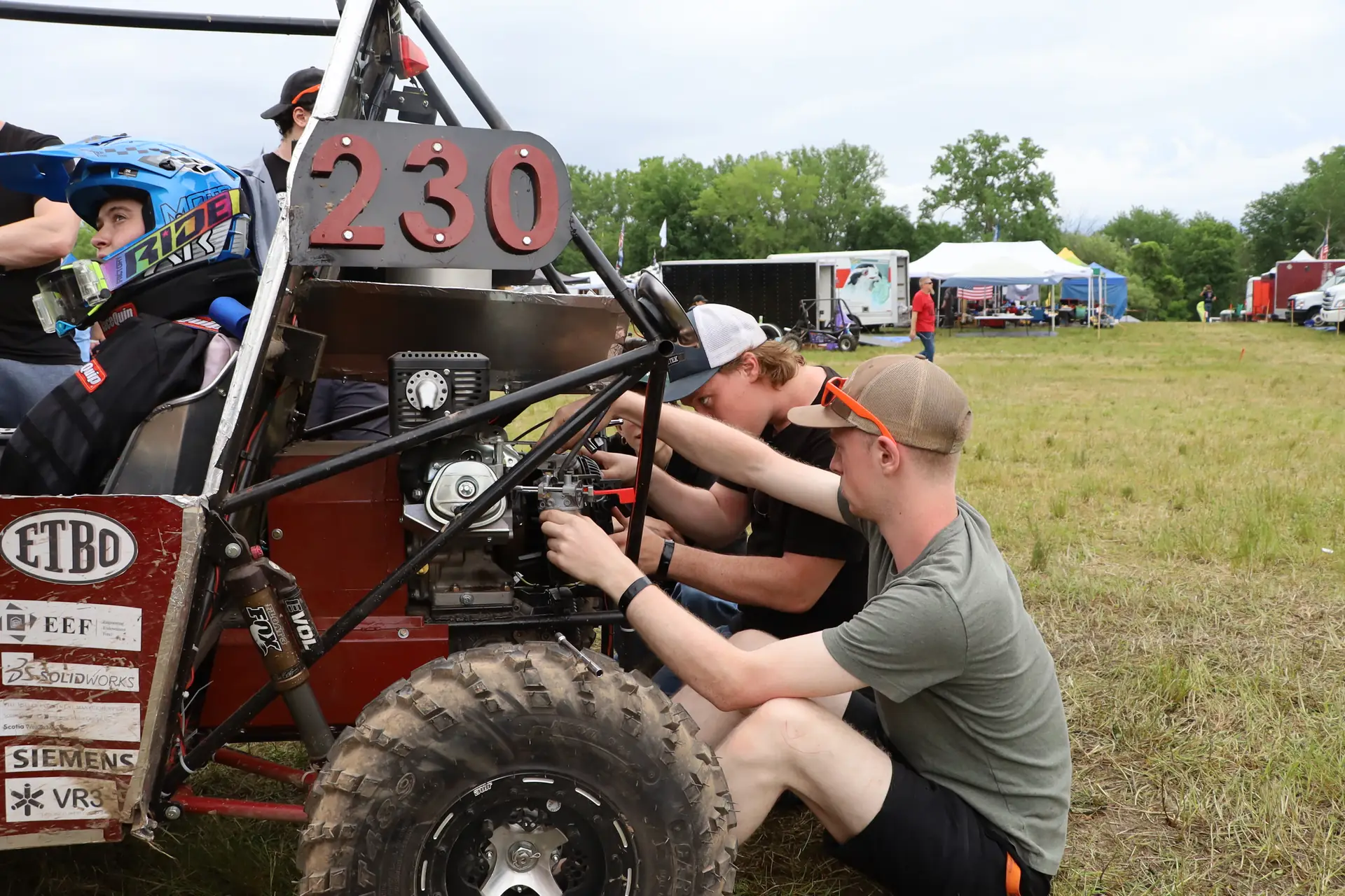Team members tuning the engine on car #230