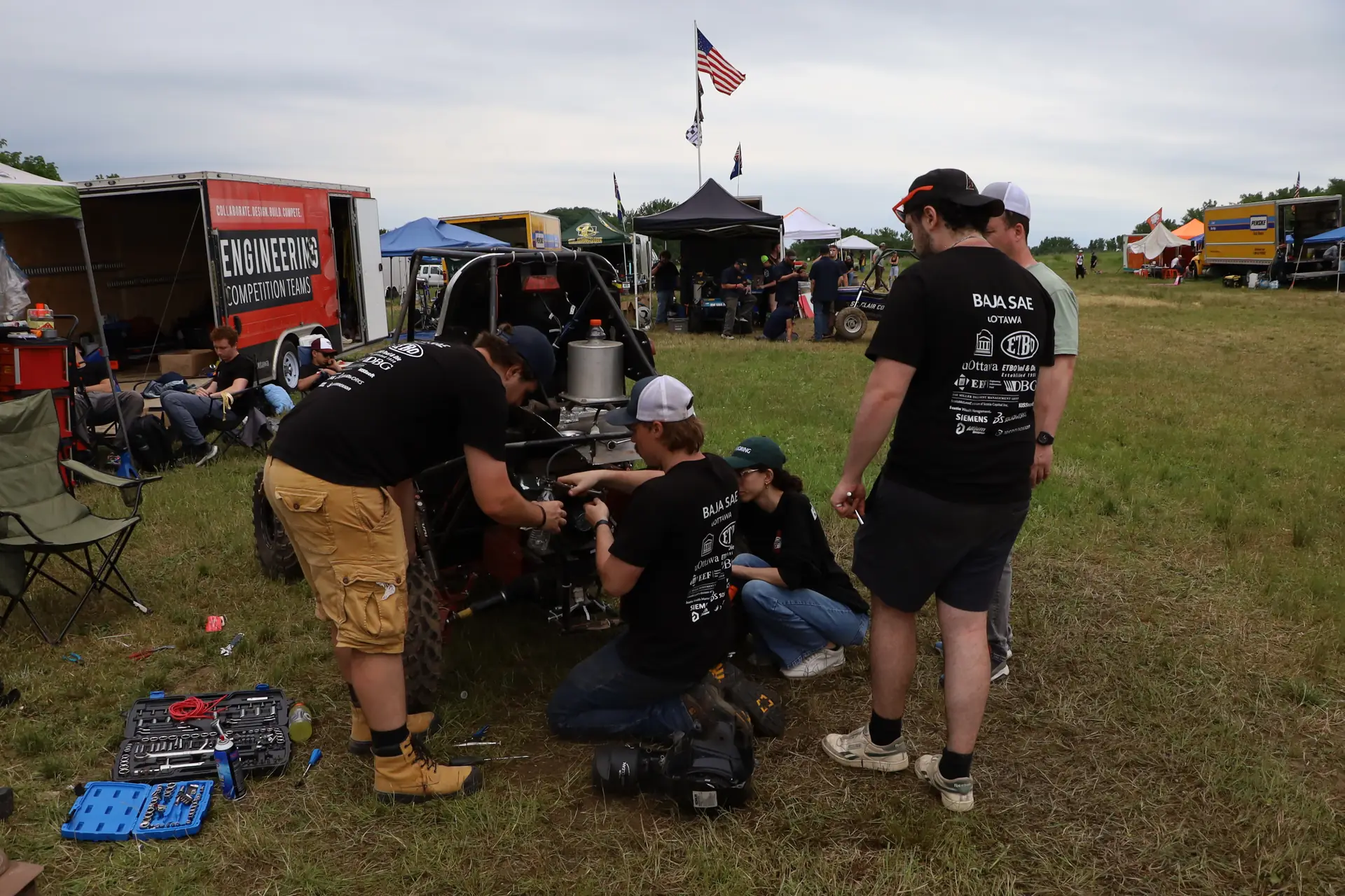 Team members working on the rear of the car